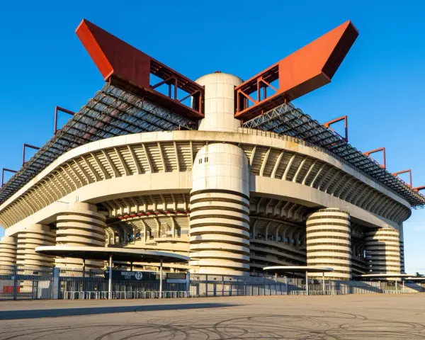 San Siro, ikona Mediolanu, czeka na wyburzenie. Monumentalna konstrukcja stadionu z czerwonymi elementami dachu i betonowymi filarami.