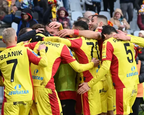 Piłkarze Korony Kielce świętują zwycięstwo nad Górnikiem Zabrze. Radość i okrzyki na boisku, kibice na trybunach.