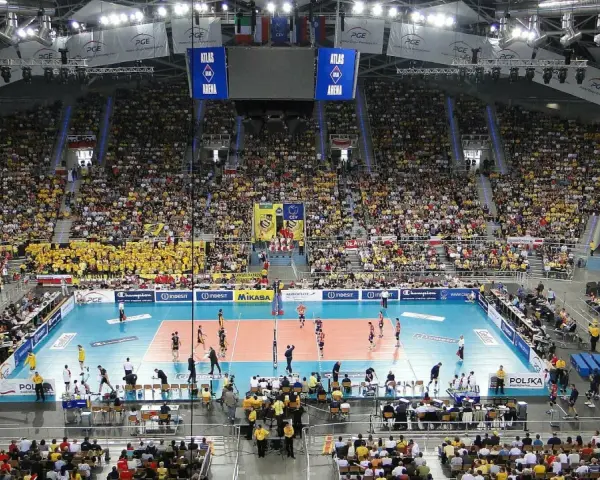Widok na pełną trybunę Atlas Arena podczas meczu siatkówki. Tysiące kibiców w żółtych barwach tworzy gorącą atmosferę.