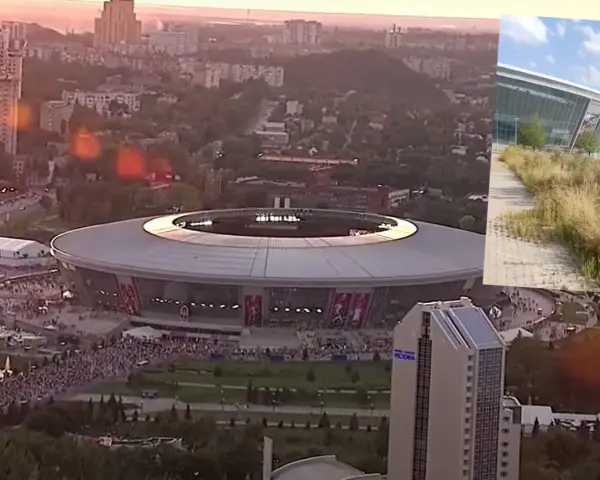Donbass Arena w blasku zachodzącego słońca, otoczona miejskim krajobrazem i tłumami ludzi.