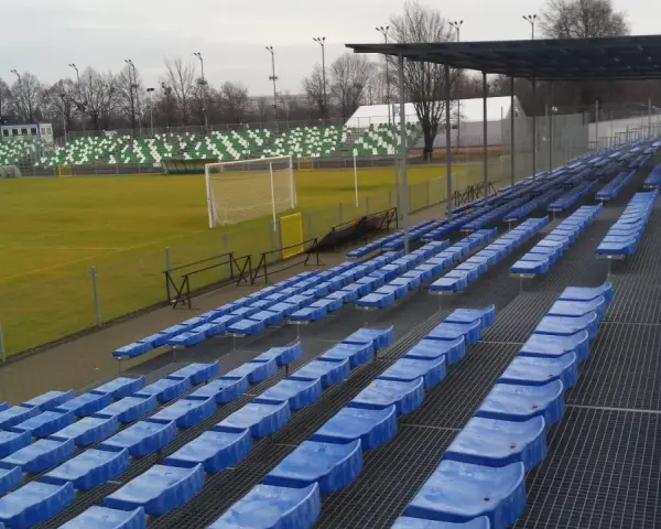 Puste niebieskie krzesełka na stadionie Warty Poznań czekają na kibiców.