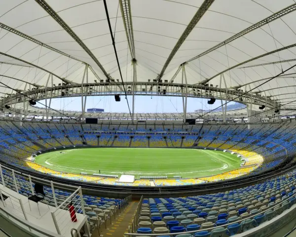 Pusta Marakana, stadion w Rio de Janeiro, z zieloną murawą i żółto-niebieskimi siedzeniami pod białym dachem.