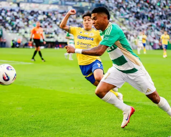Piłkarz Lechii Gdańsk w zielono-białej koszulce biegnie z piłką, ścigany przez zawodnika Arki Gdynia. Mecz składy: Arka Gdynia – Lechia Gdańsk.