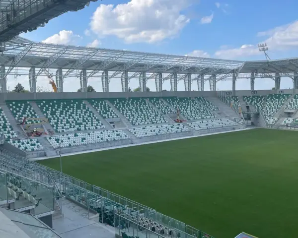 Puste sektory stadionu Radomiaka czekają na kibiców. Zielona murawa i nowoczesna konstrukcja dachu tworzą imponujący widok.