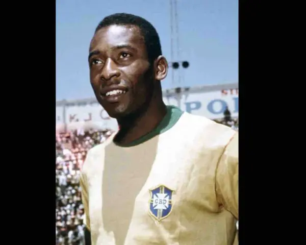 Uśmiechnięty Pelé w żółtej koszulce z herbem Brazylii. Jego niesamowite pelé statystyki mówią same za siebie.