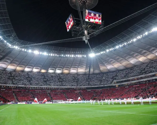 Stadion Narodowy w Warszawie, z pełną widownią, która tworzy biało-czerwony wzór. Jego imponująca pojemność robi wrażenie.