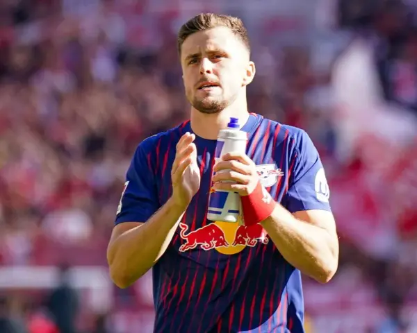 Piłkarz w koszulce RB Leipzig, jeden z zawodników 2. Bundesligi, trzyma butelkę z napojem.