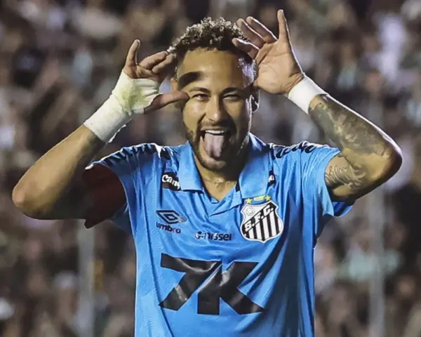 Neymar w niebieskiej koszulce Santos z charakterystycznym gestem i wystawionym językiem. Tak wygląda boisko, gdzie gra Neymar.