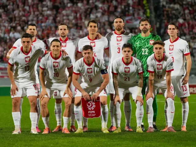 Reprezentacja Polski w piłce nożnej, w białych strojach, gotowa do meczu. Duma narodowa na boisku.