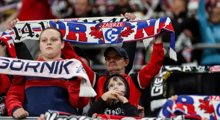 Kibice Górnika Zabrze na meczu z GKS Katowice. Widać szaliki z napisem "Górnik Zabrze" i herbem klubu.