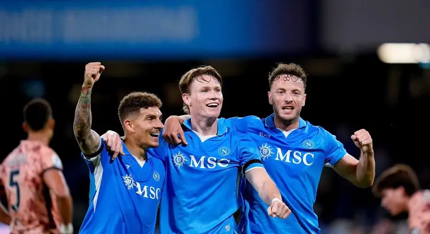 Piłkarze Napoli świętują zwycięstwo nad Hellas Verona. Radość na twarzach zawodników, jeden z nich unosi pięść w geście triumfu.