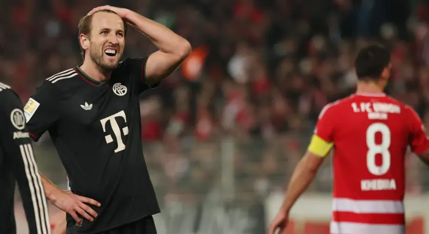 Piłkarz Bayernu w czarnej koszulce z T na piersi, z ręką na głowie, w meczu przeciwko Union Berlin.