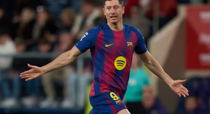 Piłkarz Robert Lewandowski w koszulce FC Barcelony z numerem 9, z rękami rozłożonymi na boki.
