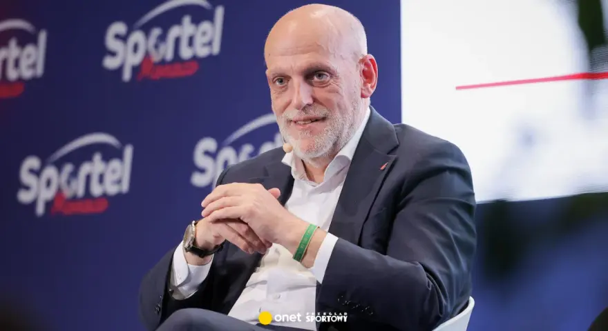 Uśmiechnięty Javier Tebas, prezes La Liga, w garniturze, na tle logo Sportel Forum.