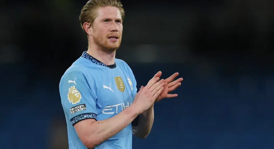 Kevin De Bruyne w błękitnej koszulce Manchesteru City klaszcze, wyrażając uznanie dla kibiców.
