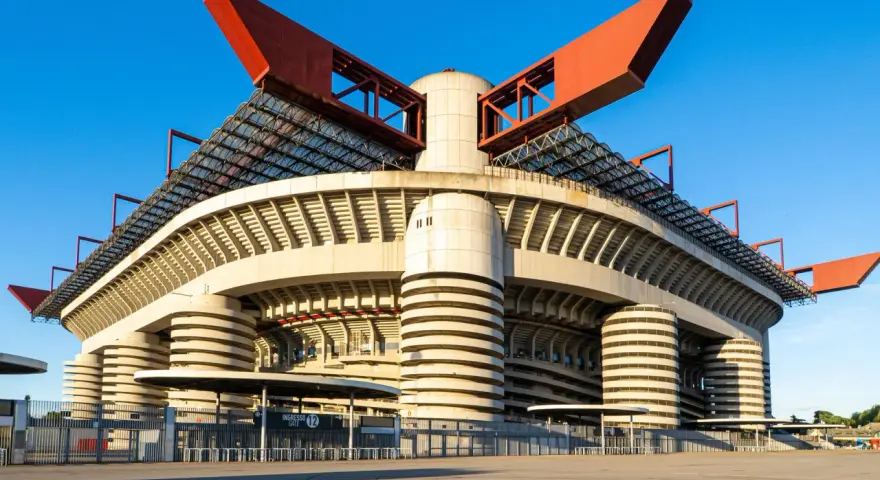 San Siro, ikona Mediolanu, czeka na wyburzenie. Monumentalna konstrukcja stadionu z czerwonymi elementami dachu i betonowymi filarami.