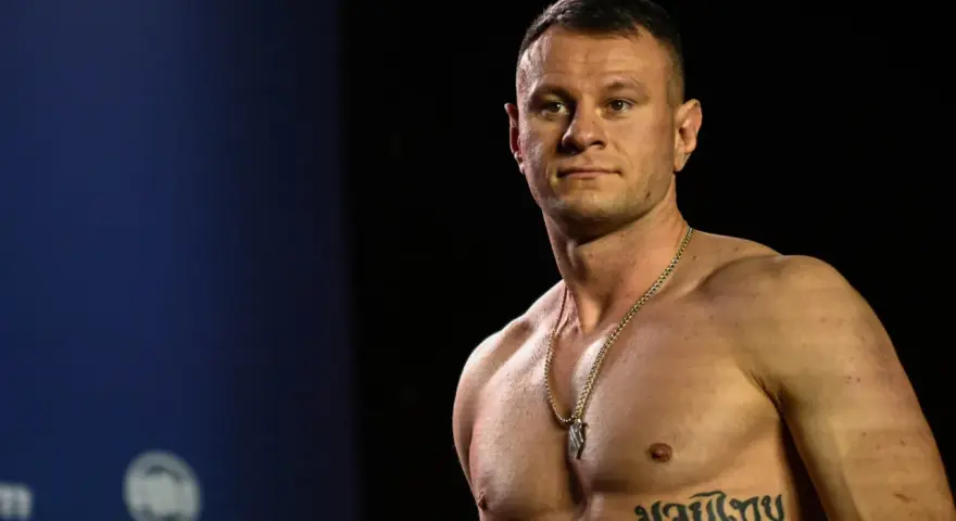 KSW relacja: Muskularny zawodnik MMA z tatuażem na klatce piersiowej pozuje przed kamerą.