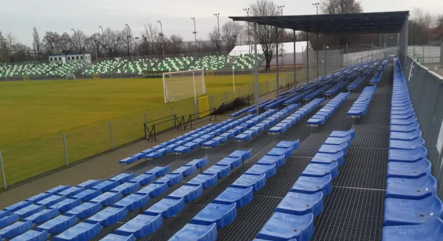 Puste niebieskie krzesełka na stadionie Warty Poznań czekają na kibiców.