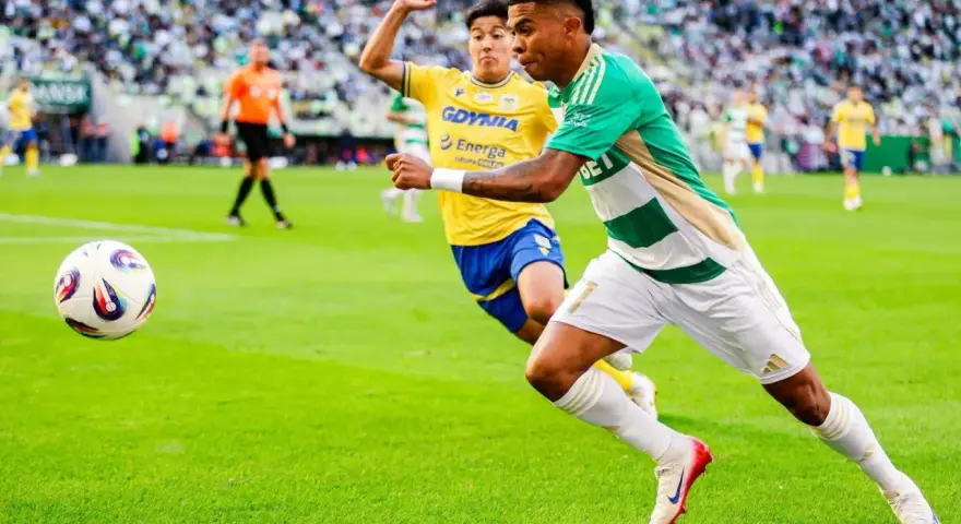 Piłkarz Lechii Gdańsk w zielono-białej koszulce biegnie z piłką, ścigany przez zawodnika Arki Gdynia. Mecz składy: Arka Gdynia – Lechia Gdańsk.