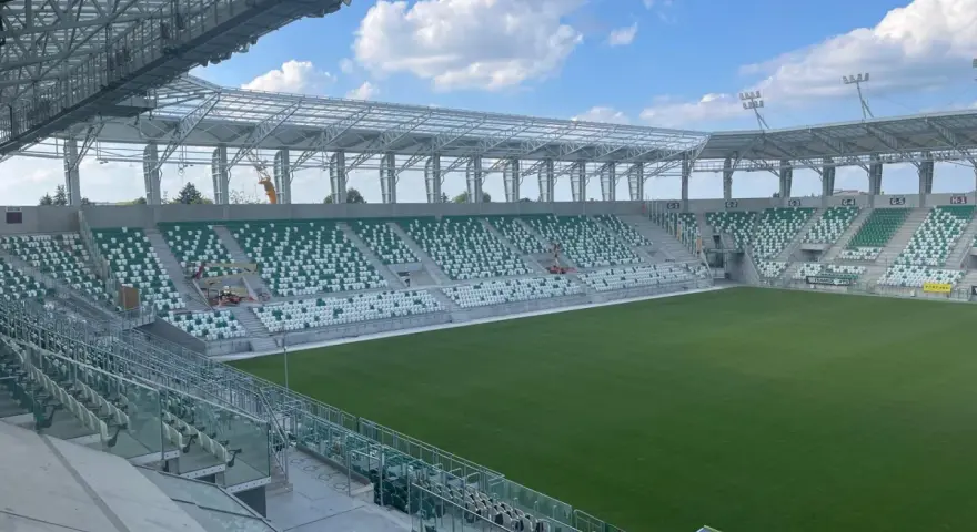 Puste sektory stadionu Radomiaka czekają na kibiców. Zielona murawa i nowoczesna konstrukcja dachu tworzą imponujący widok.