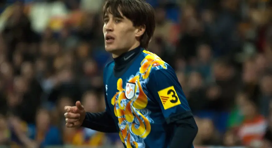 Bojan Krkić w akcji, jego bojan krkić statystyki są imponujące. Piłkarz w niebieskiej koszulce z żółtym wzorem.