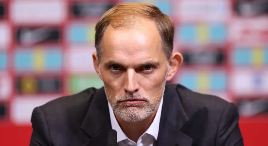 Thomas Tuchel, były trener Chelsea, z poważną miną przed mikrofonem.