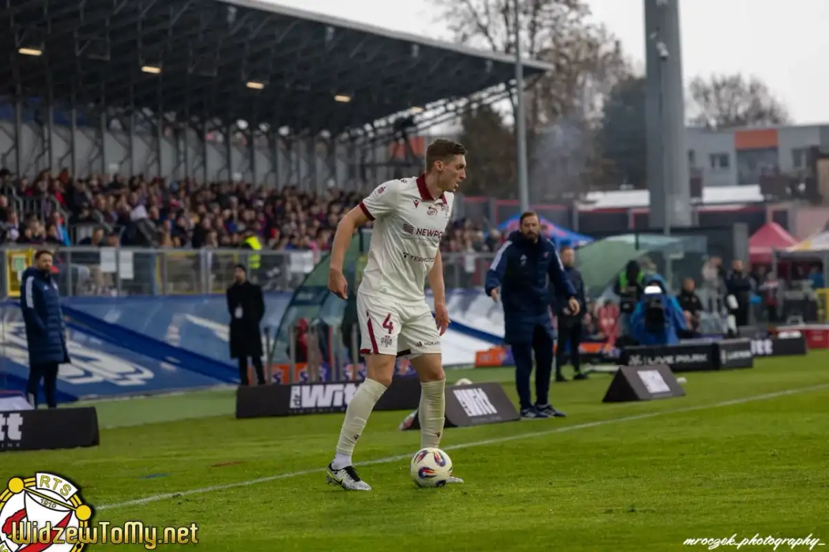 Piłkarz w białej koszulce z numerem 4, przygotowuje się do gry podczas meczu Raków Częstochowa – Widzew Łódź.