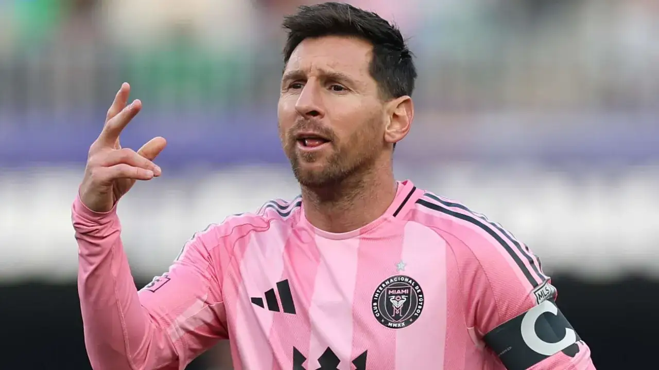 Lionel Messi w różowej koszulce Interu Miami, gdzie gra, gestykuluje na boisku.
