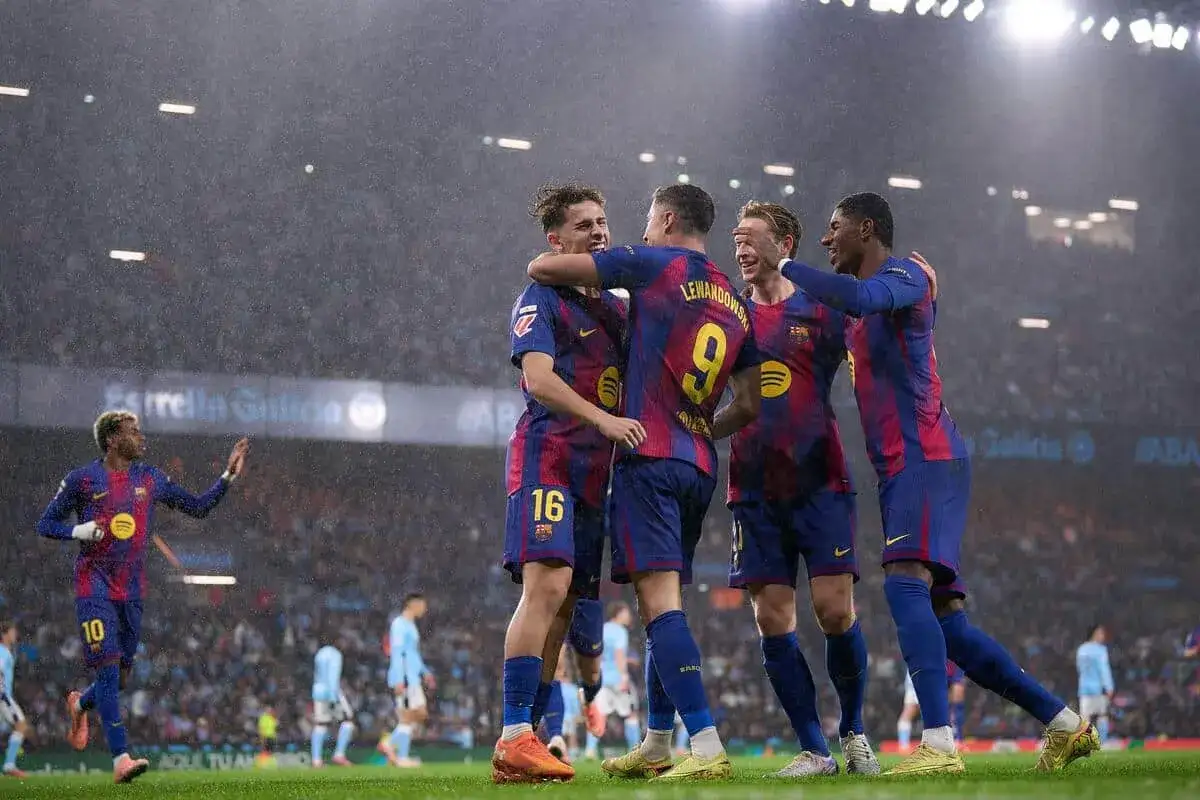 Radosna feta strzelców Barcelony w deszczu. Lewandowski z numerem 9 świętuje z kolegami.