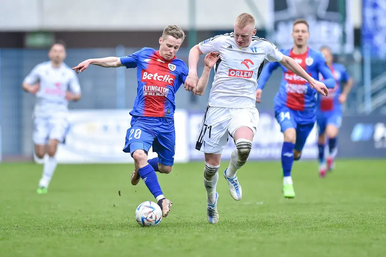Piast Gliwice kontra Wisła Płock. Piłkarze walczą o piłkę na murawie.