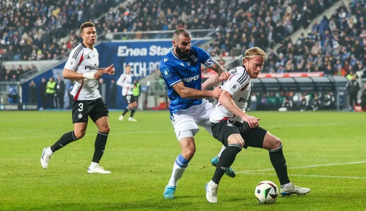 Piłkarze walczą o piłkę na boisku, gdy rusza ekstraklasa. W tle trybuny pełne kibiców.