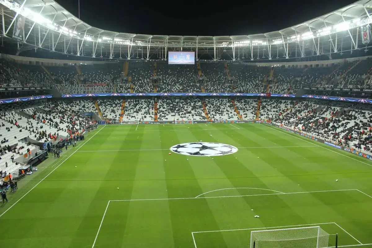 Stadion przed meczem Ligi Mistrz&oacute;w. Na murawie wielkie logo Champions League, a trybuny wypełnione kibicami. Kto wygrywał w tych rozgrywkach?