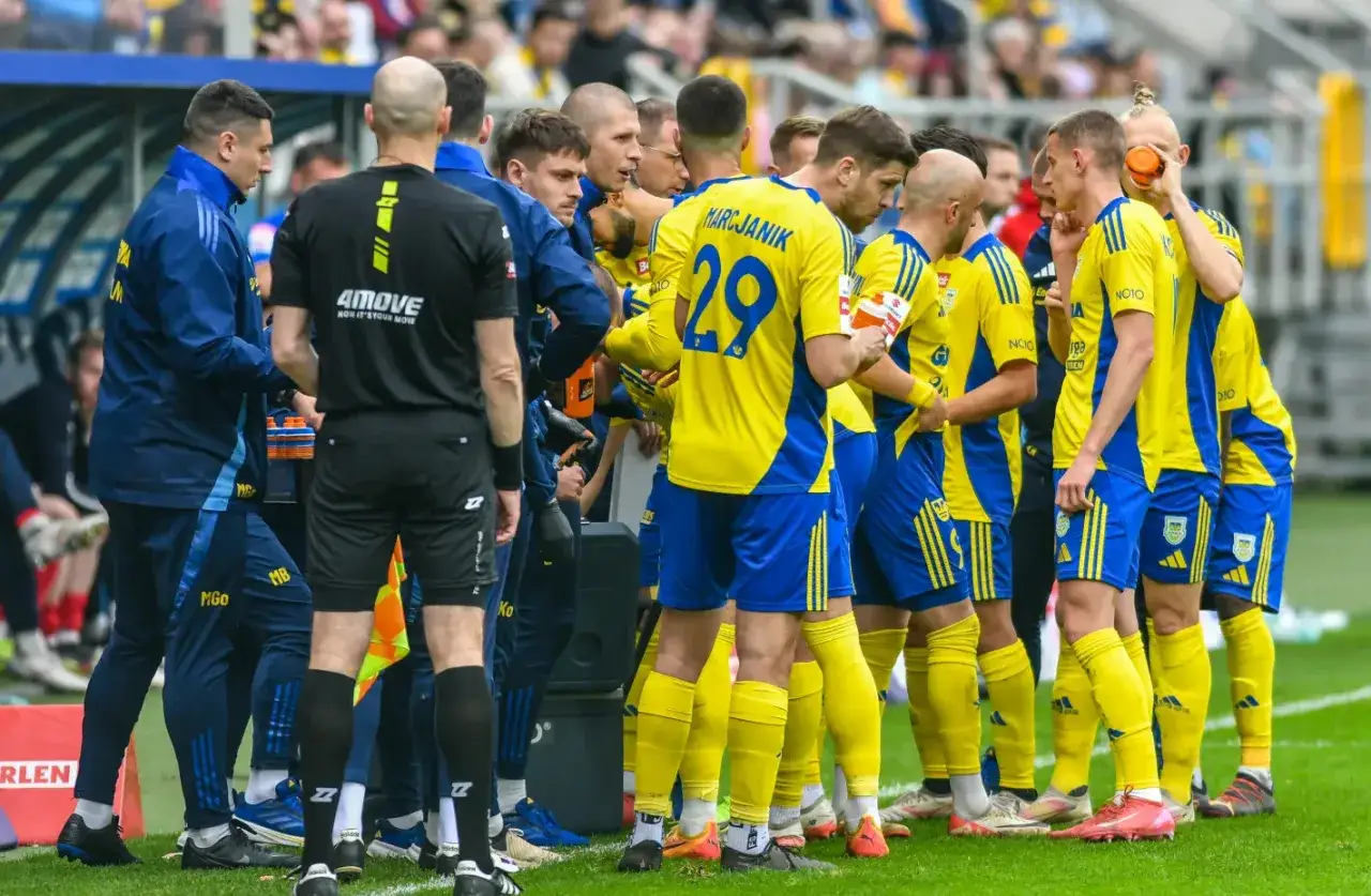 Piłkarze w żółto-niebieskich strojach świętują awans do Ekstraklasy.
