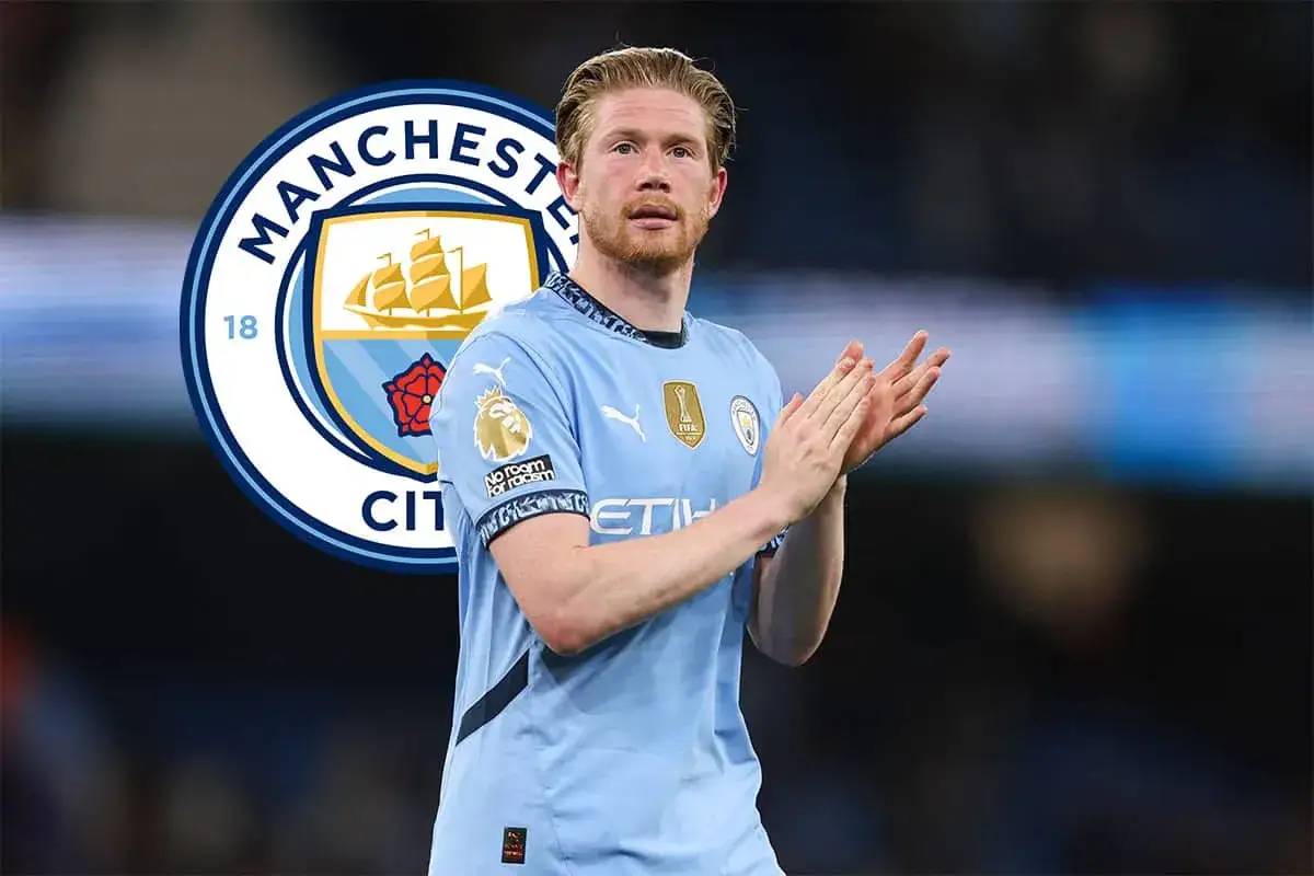 Kevin De Bruyne w błękitnej koszulce Manchesteru City, z symbolem klubu w tle, klaszcze w dłonie.