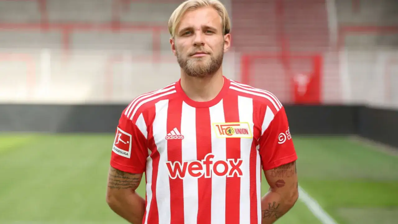 Tymek Puchacz w czerwono-białej koszulce Union Berlin, gotowy do gry.