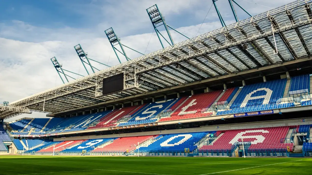 Stadion Wisły Kraków, z czerwono-niebieskimi trybunami tworzącymi napis