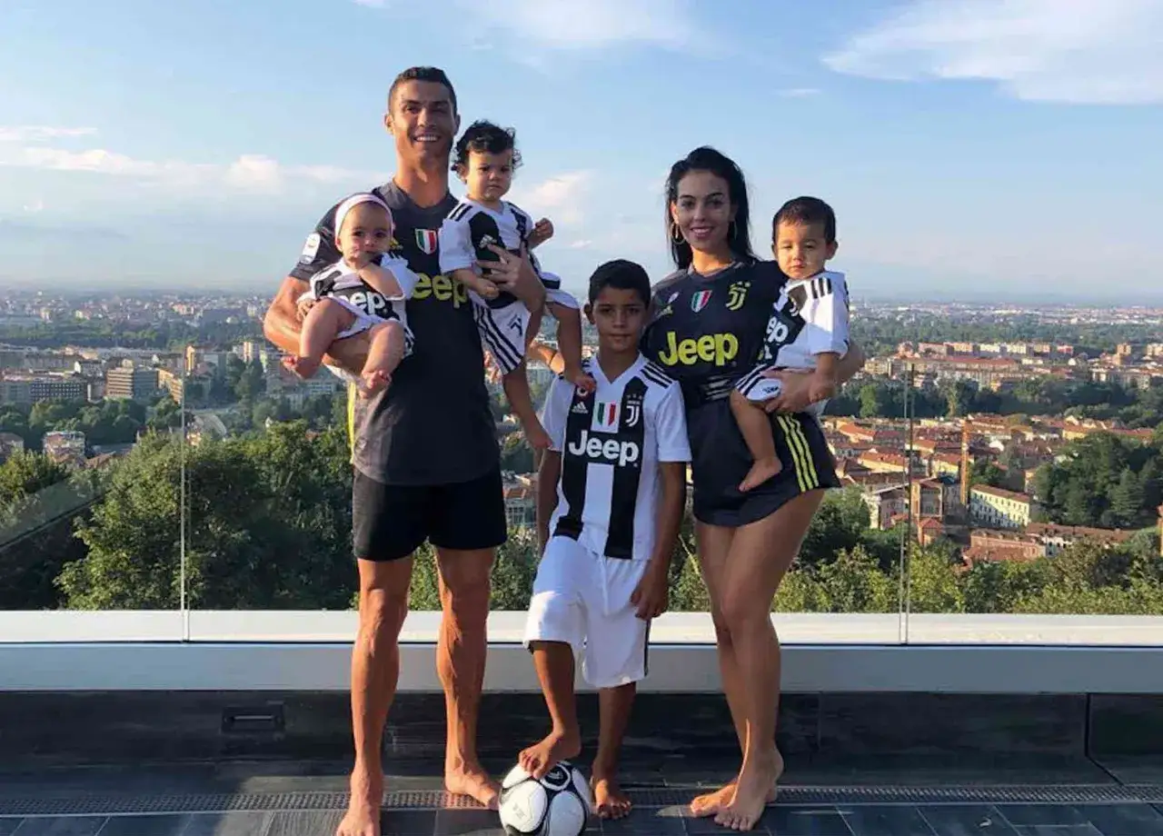 Cristiano Ronaldo z rodziną, w tym z dziećmi, na tle miasta.