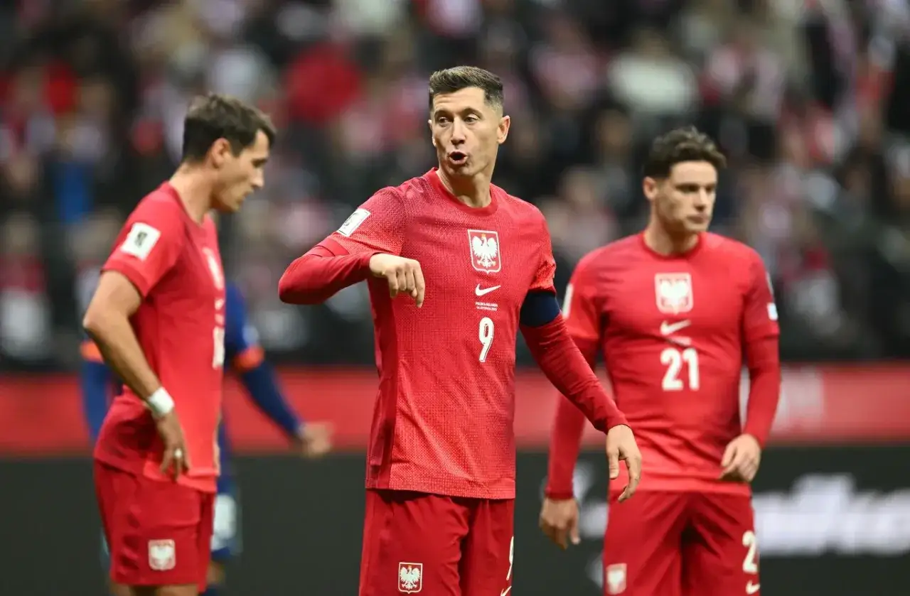 Robert Lewandowski i koledzy z drużyny w czerwonych strojach, gotowi do gry, kiedy gra polska w piłkę nożną.