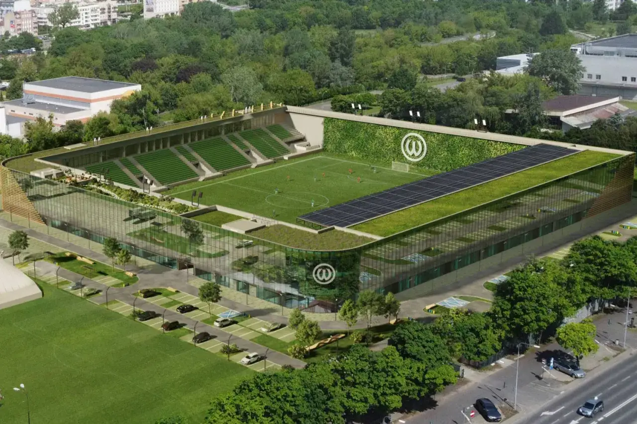 Nowoczesny stadion Warty Poznań z zielonymi dachami, panelem słonecznym i pionową ścianą zieleni.