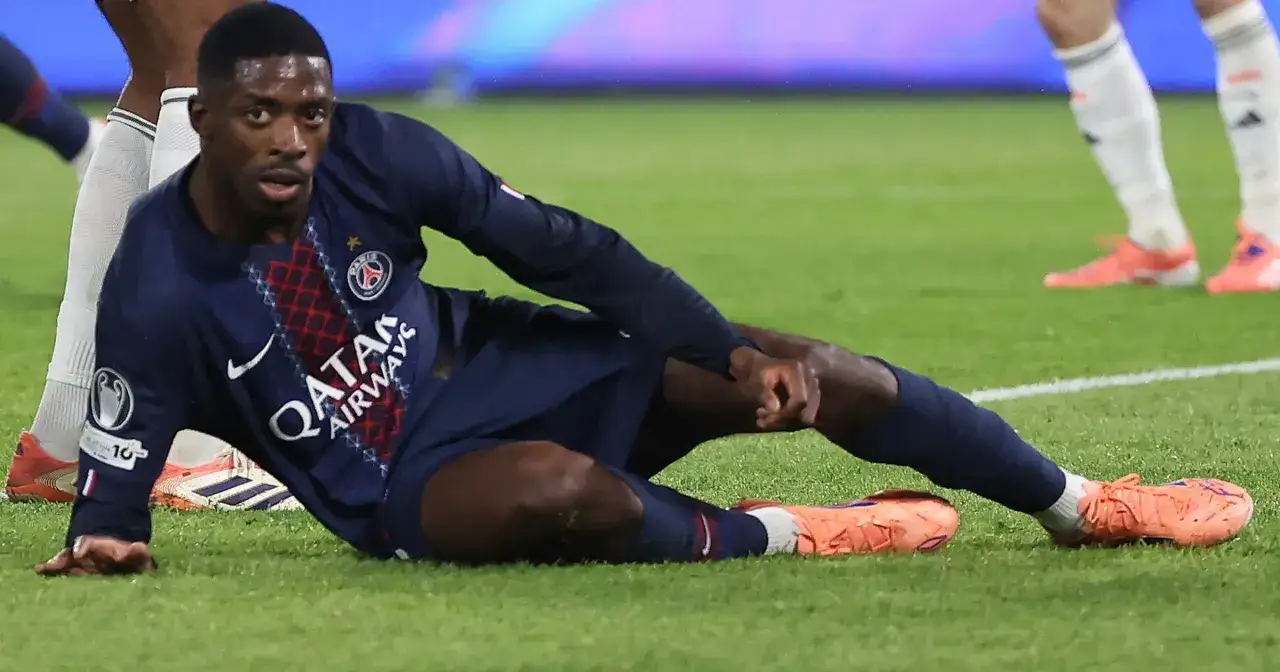 Piłkarz PSG Ousmane Dembélé leży na murawie, trzymając się za nogę. Wygląda na to, że to dembele kontuzja.