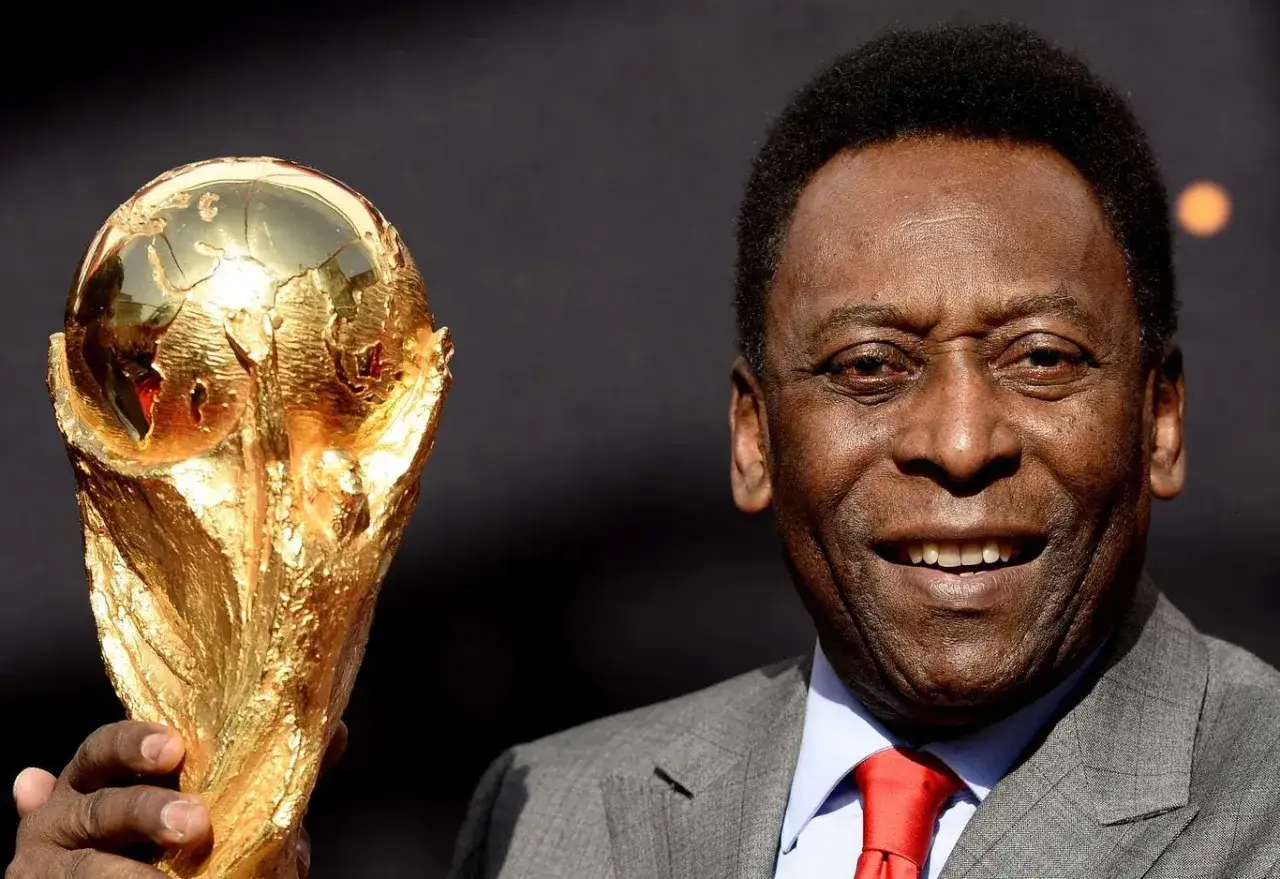 Uśmiechnięty Pelé trzymający Złotą Nike. Ile złotych piłek ma Pelé? Trzy!