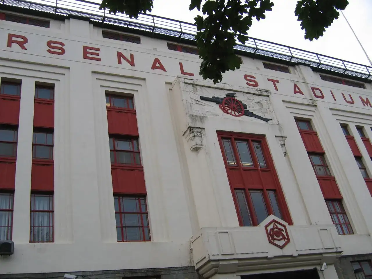 Fasada stadionu Arsenal w Highbury z czerwonymi oknami i napisem 